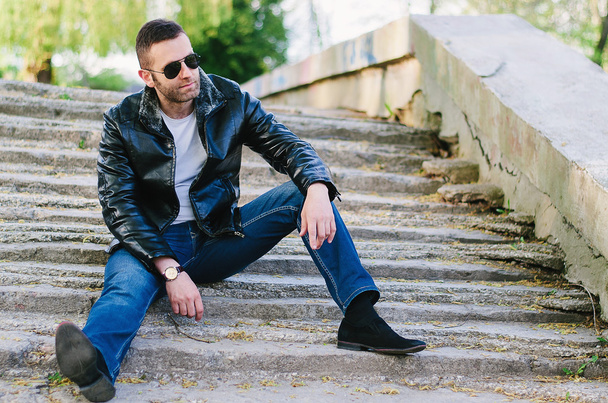 Young, fashioned man in black leather jacket, sunglasses and jea - Fotoğraf, Görsel