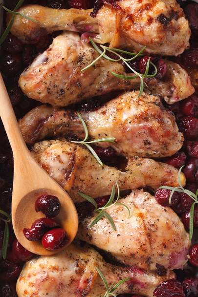 Baked chicken leg with cherry macro. Vertical top view - Photo, Image
