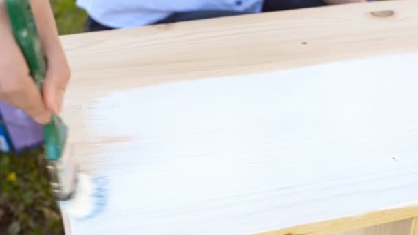 Main féminine avec peinture au pinceau meubles en bois
. - Séquence, vidéo
