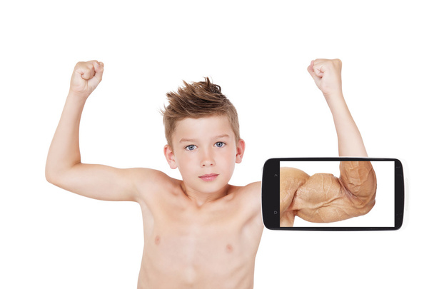 Очаровательный мальчик показывает мышцы с будущим видением на экране смартфона
 - Фото, изображение