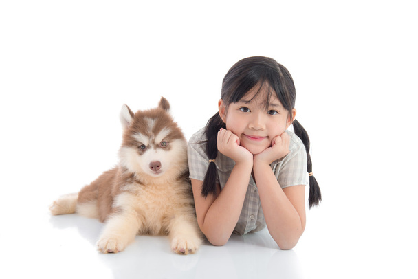 Beautiful asian girl and  siberian husky puppy lying on white ba - Photo, Image