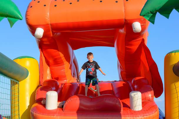 Boy Playing on Giant Red Inflatable Hippopotamus - Фото, зображення