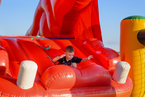Small boy (6-8 years) plays in bouncy castle - Zdjęcie, obraz