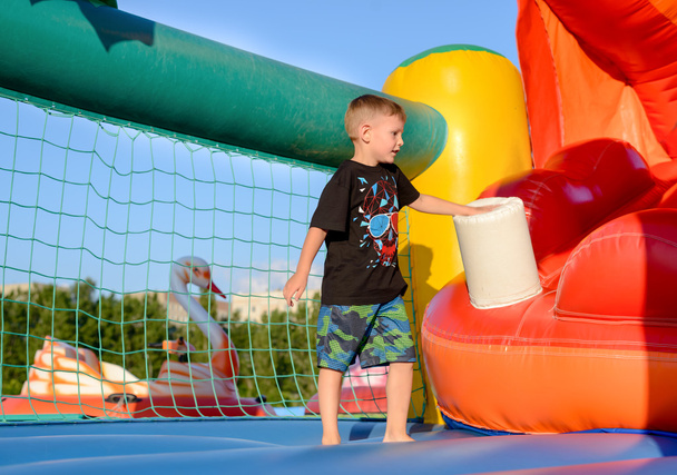 Blonde boy (7-9 years) in bouncy castle - Foto, afbeelding