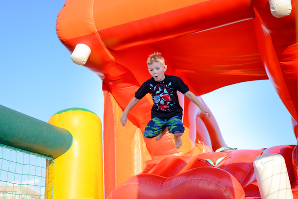 Small boy having fun on a jumping castle - Photo, Image
