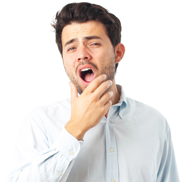 tired man with yawn gesture on a white background - 写真・画像
