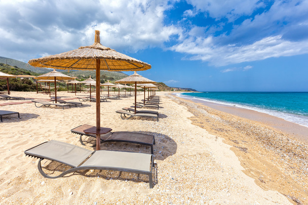 Parapluies en rangées sur la plage de sable avec mer
 - Photo, image