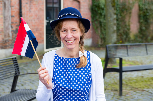 Mulher europeia que celebra a libertação com bandeira holandesa
 - Foto, Imagem
