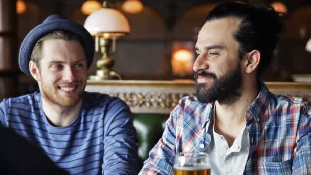 happy male friends drinking beer at bar or pub - Materiaali, video