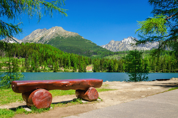 Banco, lago de montaña y picos
 - Foto, imagen