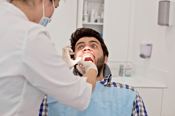 young man and woman in a dental examination at dentist - Zdjęcie, obraz