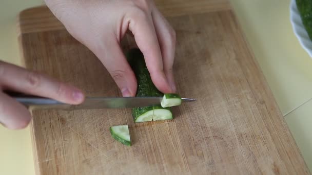 Hand snijden komkommer op snijplank met scherp mes - Video