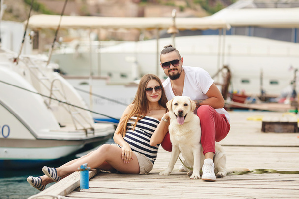 Young couple on a walk in the Harbor with a white Labrador - Photo, image