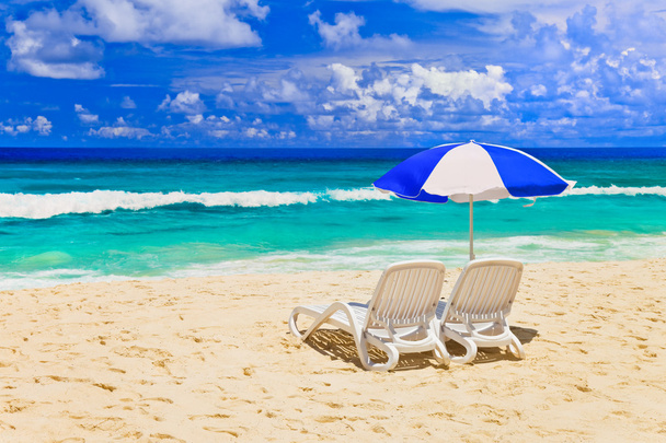 Chairs and umbrella at tropical beach - Foto, afbeelding