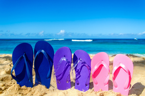 Värikkäitä sandaaleja hiekkarannalla
 - Valokuva, kuva