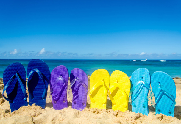 Πολύχρωμες σαγιονάρες στην αμμώδη παραλία - Φωτογραφία, εικόνα