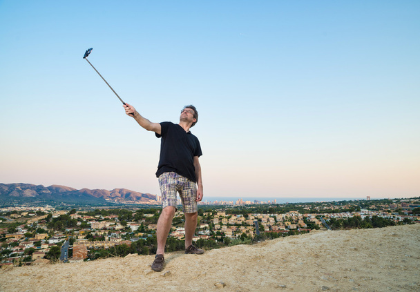 Guy with selfie stick - Foto, afbeelding