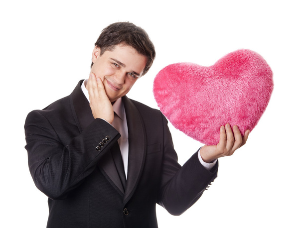 A man holding toy heart in formal black tux with tie isolated on - Photo, Image