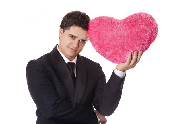 Un hombre sosteniendo el corazón de juguete en esmoquin negro formal con corbata aislada en
 - Foto, Imagen