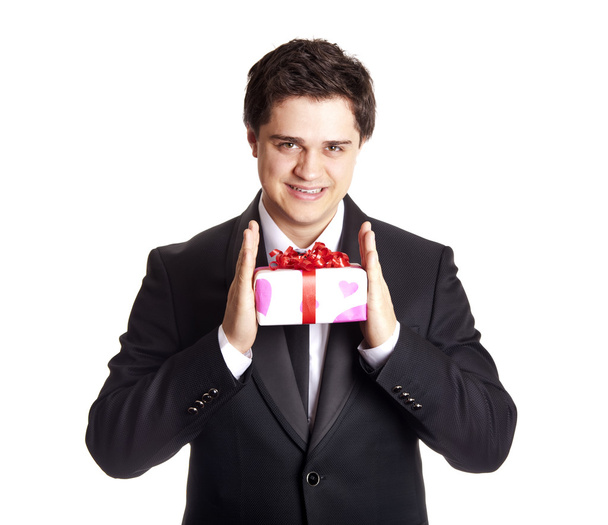 A man holding present box in formal black tux - Fotoğraf, Görsel