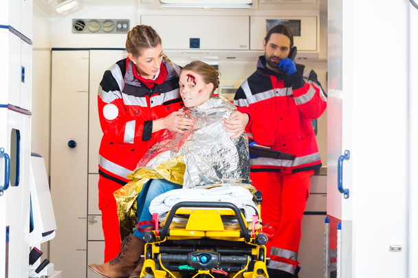 Ambulancia ayudando a la mujer lesionada
 - Foto, imagen
