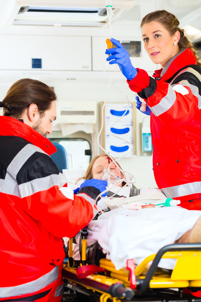 Ambulância ajudando a mulher ferida com infusão
 - Foto, Imagem