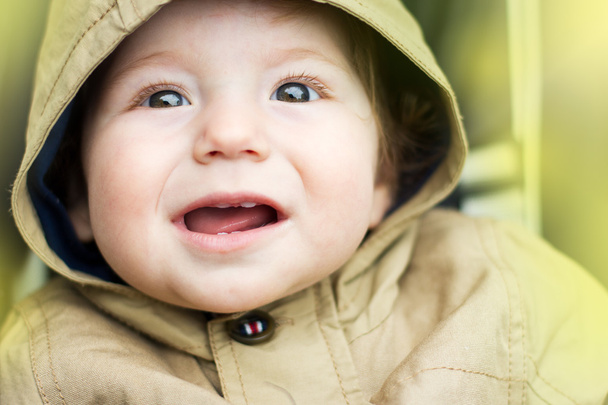 The cheerful child on a walk. Portrait of a baby in a jacket - Foto, Bild