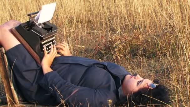 Смішна жінка набирає Вінтажний друкарський верстат лежить на стільці на природі
 - Кадри, відео