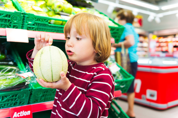 Little boy choosing fruits in a food store - Foto, Bild