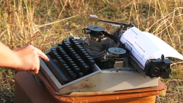 Frau tippt in der Natur auf Vintage-Schreibmaschine - Filmmaterial, Video