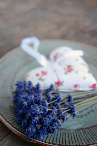 Лавандовый цветок и лавандовый мешок на столе
 - Фото, изображение