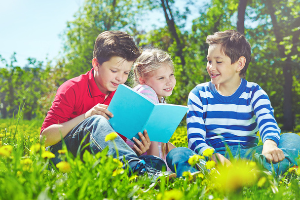 Kinder mit Buch auf Rasen - Foto, Bild