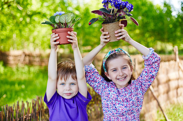 Kinder mit neu gepflanzten Veilchen - Foto, Bild