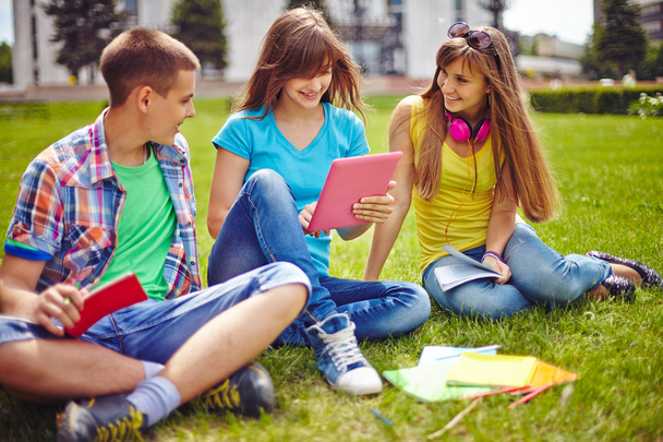 Adolescentes amigáveis sentados no gramado
 - Foto, Imagem