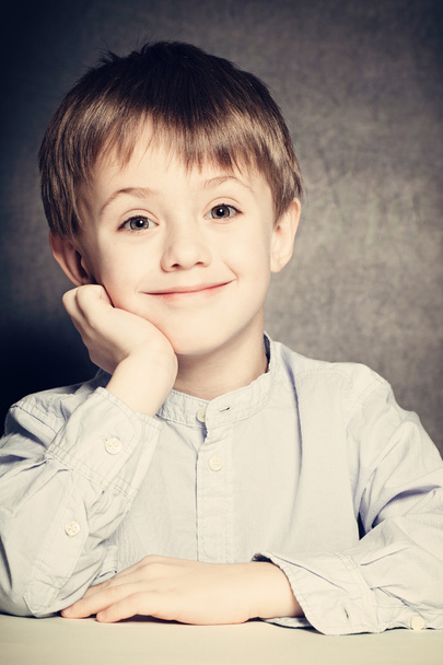 Sorridente bambino ragazzo si siede a una scrivania della scuola
 - Foto, immagini