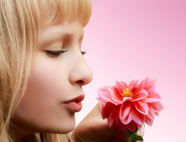 Hermosa chica con flor sobre fondo rosa
 - Foto, imagen