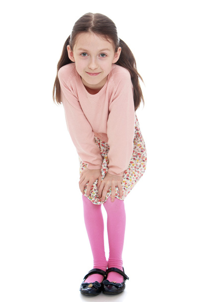 Cheerful girl in a dress and pink cardigan liked put his hands o - Photo, Image