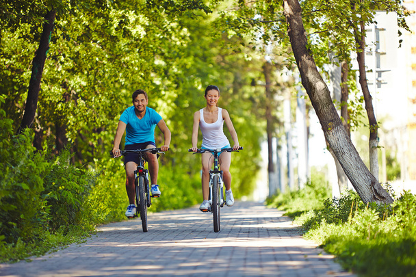 男と公園で自転車に乗る女 - 写真・画像