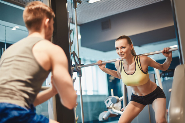 Frau schaut Trainerin beim Gewichtheben an - Foto, Bild