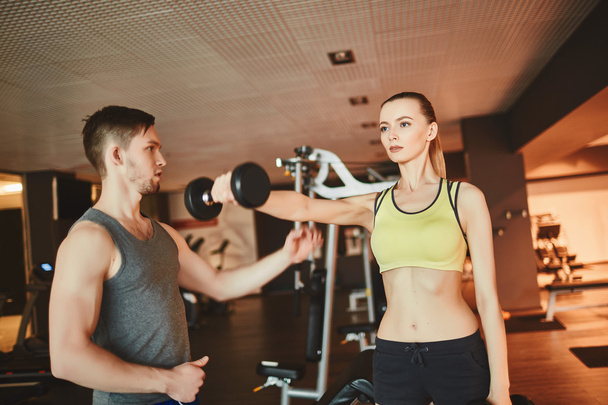 woman holding barbell with trainer near by - Valokuva, kuva