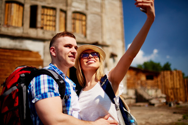 man and woman with backpacks making selfie - Photo, Image