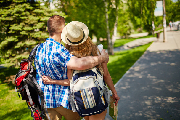couple with backpacks hugging and walking - Photo, Image
