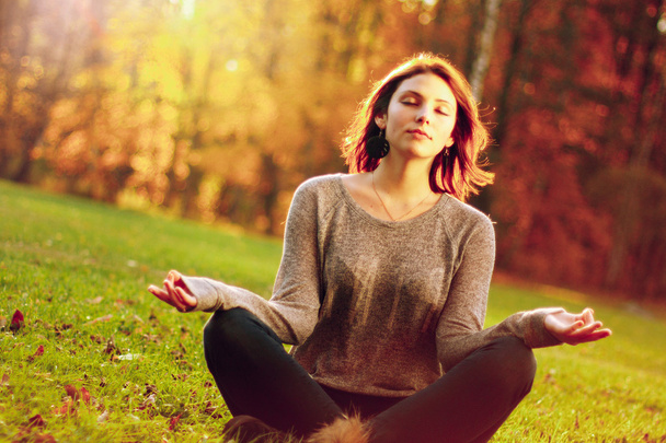 young girl meditating in autumn park - Фото, изображение