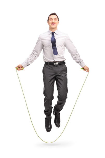 Young cheerful businessman jumping a rope  - Фото, зображення