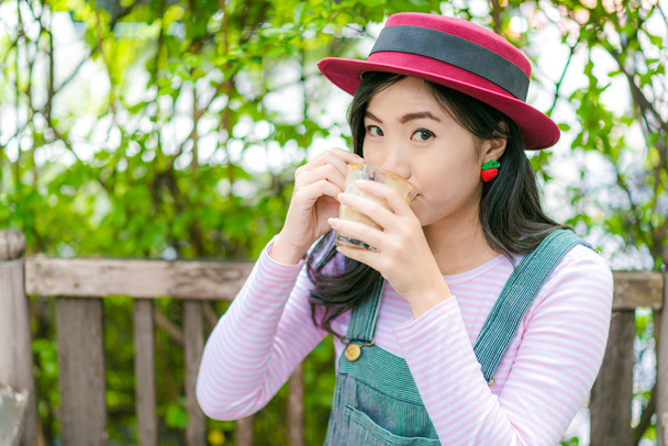 Beautiful young  asian girl in outdoor cafe drinking coffee. - Φωτογραφία, εικόνα