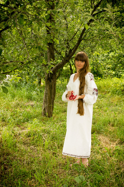 Nuori tyttö Ukrainan kirjailtu paita, seisoo paljain jaloin
 - Valokuva, kuva