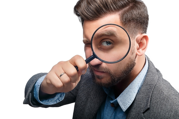 Man with magnifying glass on white background - Foto, Imagen