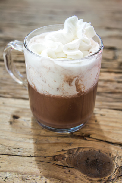 chocolate drink with whipped cream in transparent cup on wooden  - Фото, зображення