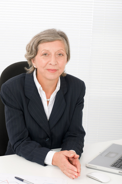 Senior businesswoman smile sit behind office desk - Foto, imagen