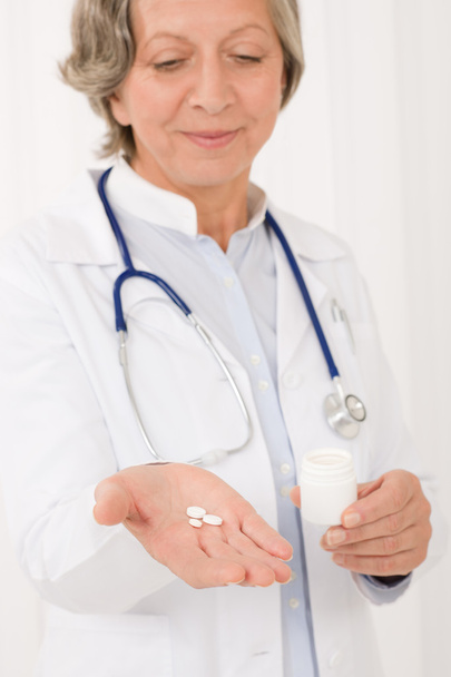 Senior doctor female hold pills looking down - Fotografie, Obrázek